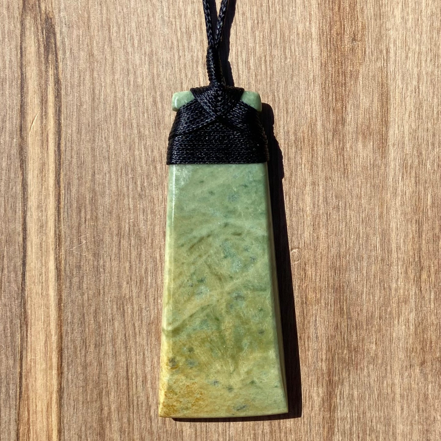 Bound toki pendant hand-carved from New Zealand flower jade/ pounamu (greenstone). Front.