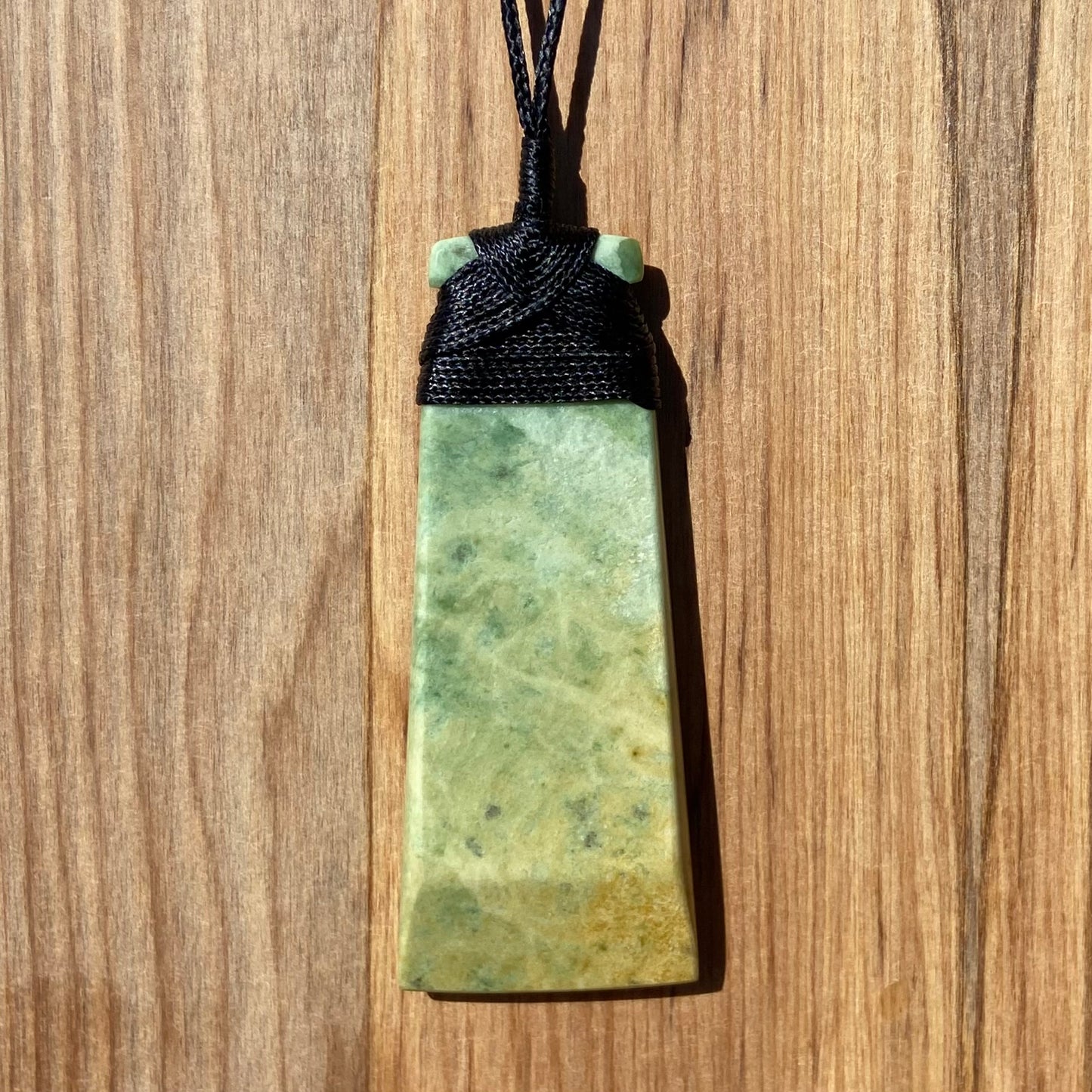 Bound toki pendant hand-carved from New Zealand flower jade/ pounamu (greenstone). Back.