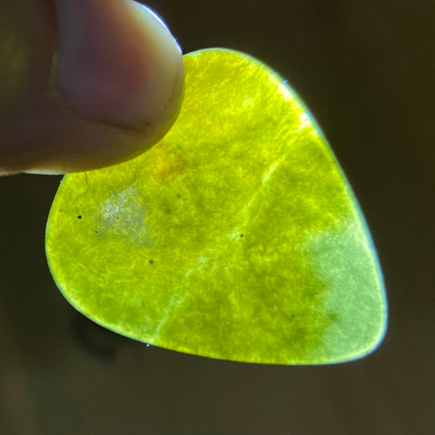 Guitar pick hand-carved from New Zealand Kawakawa Greenstone pounamu (greenstone). Translucency.