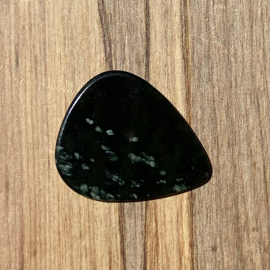 Guitar pick hand-carved from New Zealand tangiwai pounamu (greenstone). Front.