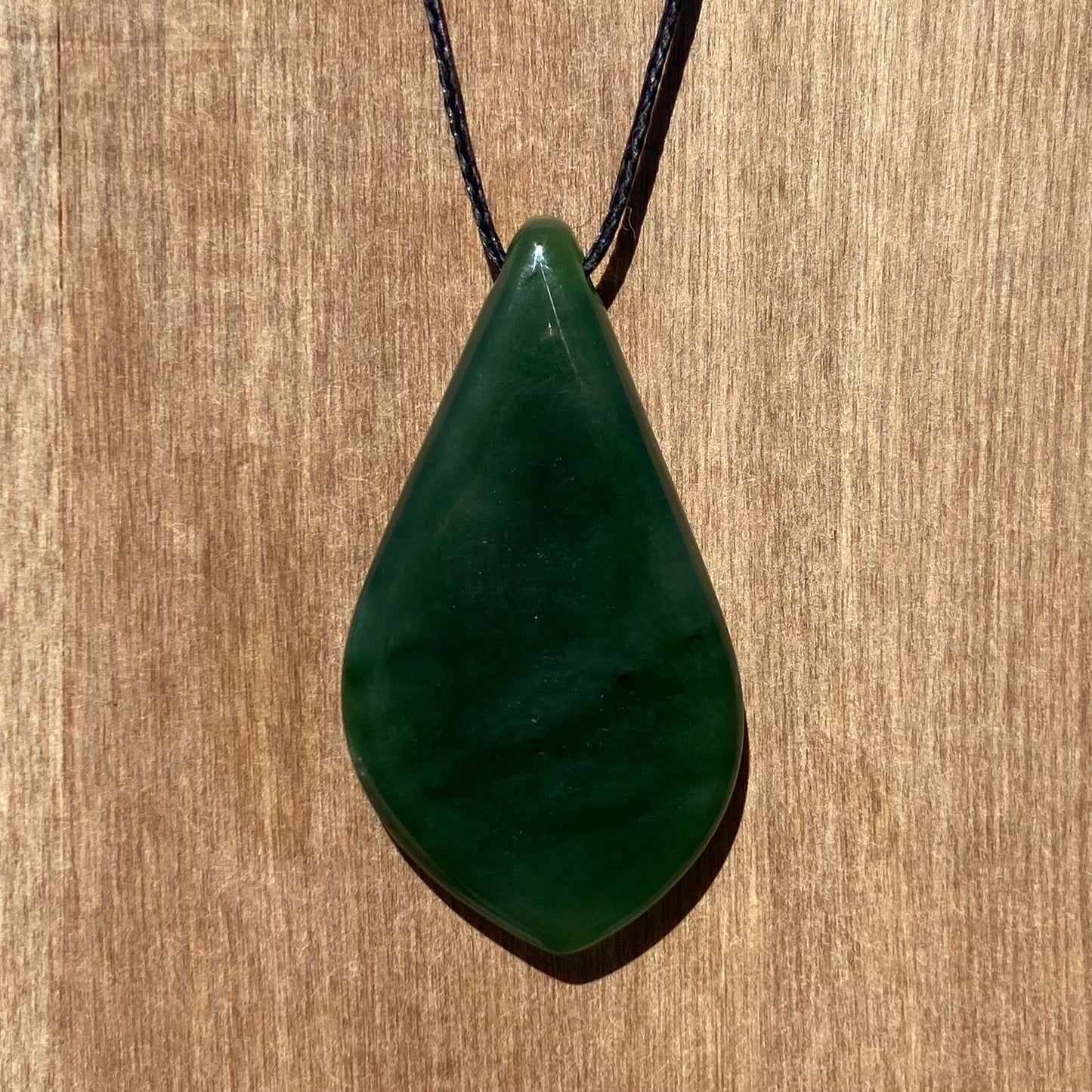 Freeform shape pendant hand-carved from New Zealand kahurangi  pounamu (greenstone). Back.