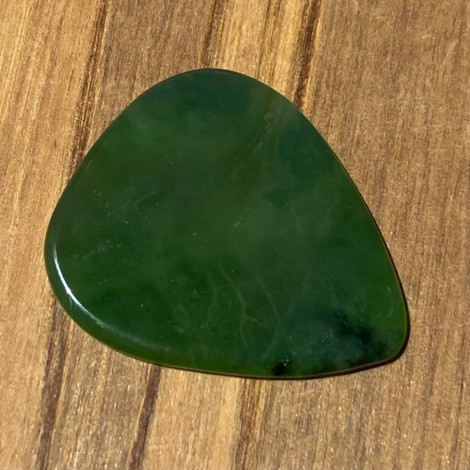 Guitar pick hand-carved from New Zealand Kahurangi Greenstone pounamu (greenstone). Front.