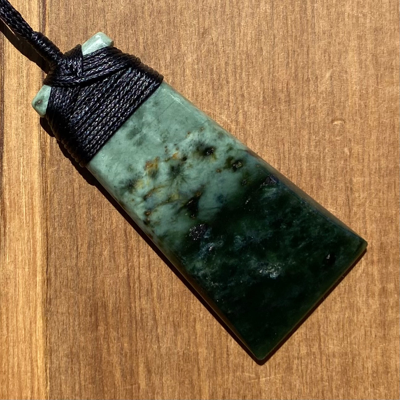 Pounamu bound toki from New Zealand Kawakawa pounamu (greenstone). Angle.