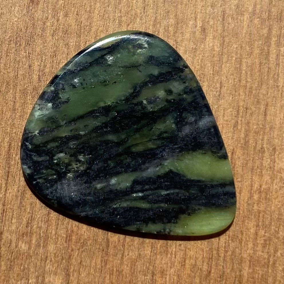 Guitar pick hand-carved from New Zealand Douglas Creek pounamu (greenstone). Back