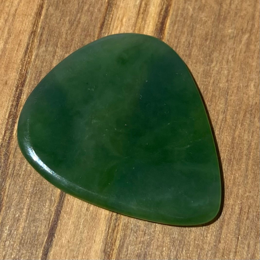 Guitar pick hand-carved from New Zealand Kahurangi Greenstone pounamu (greenstone). Front.