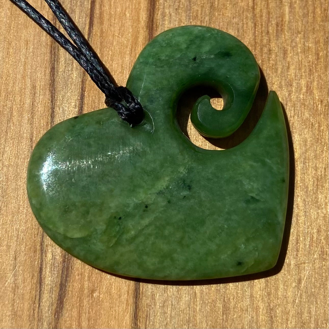 Koru heart shape pendant carved from New Zealand Marsden Flower Jade (greenstone). Back.