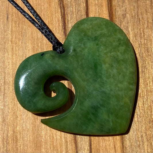 Koru heart shape pendant carved from New Zealand Marsden Flower Jade (greenstone). Front.
