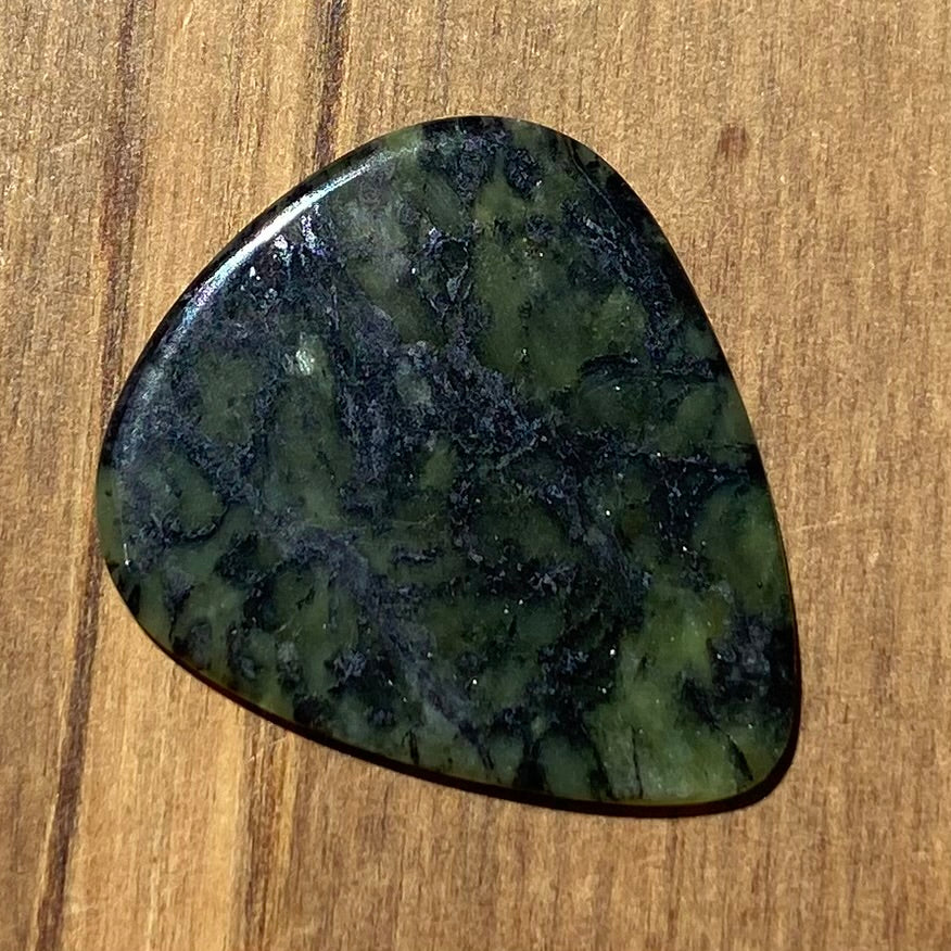 Guitar pick hand-carved from New Zealand Douglas Creek pounamu (greenstone). Back.