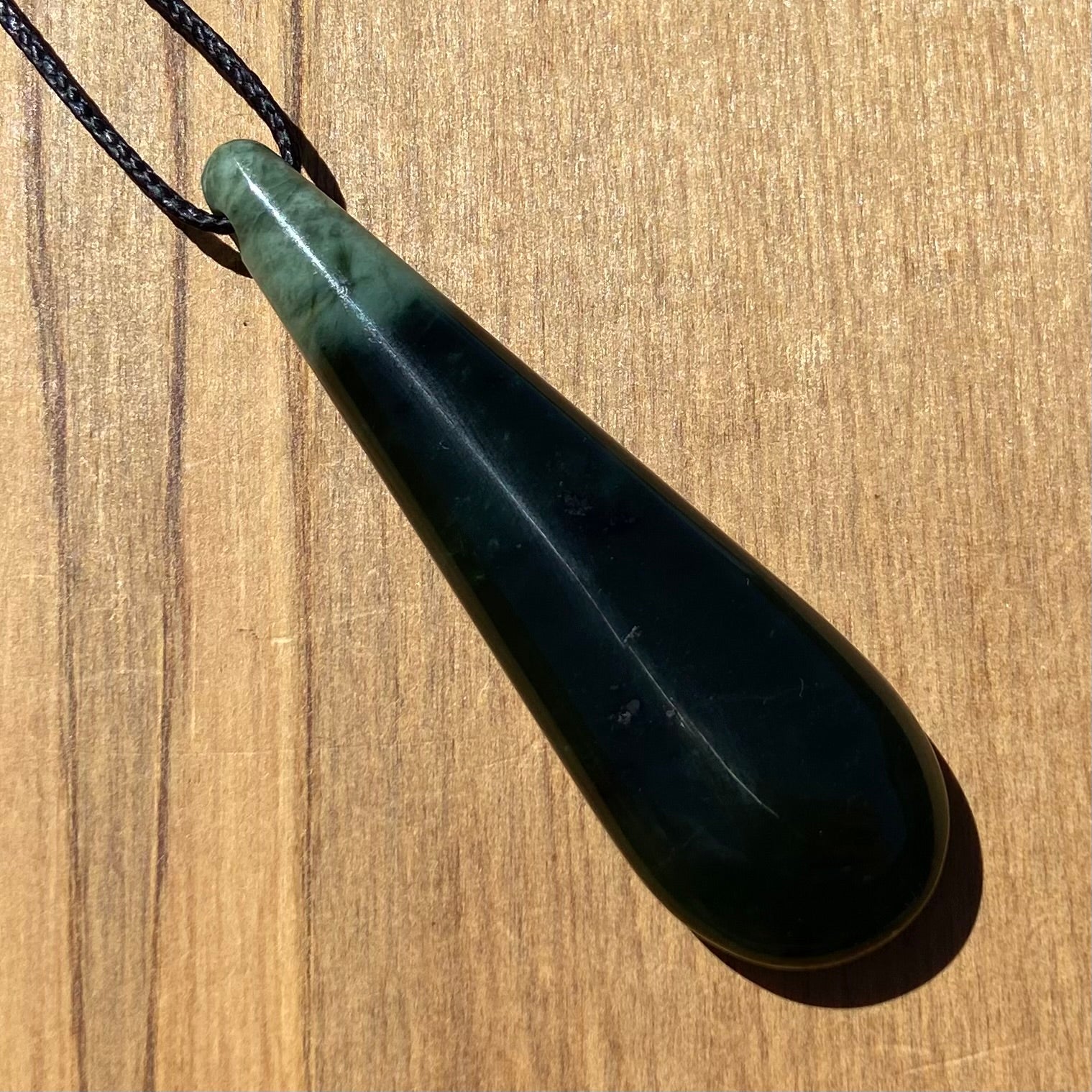 Toki pendant hand-carved from New Zealand kawawkawa pounamu (greenstone). Back.