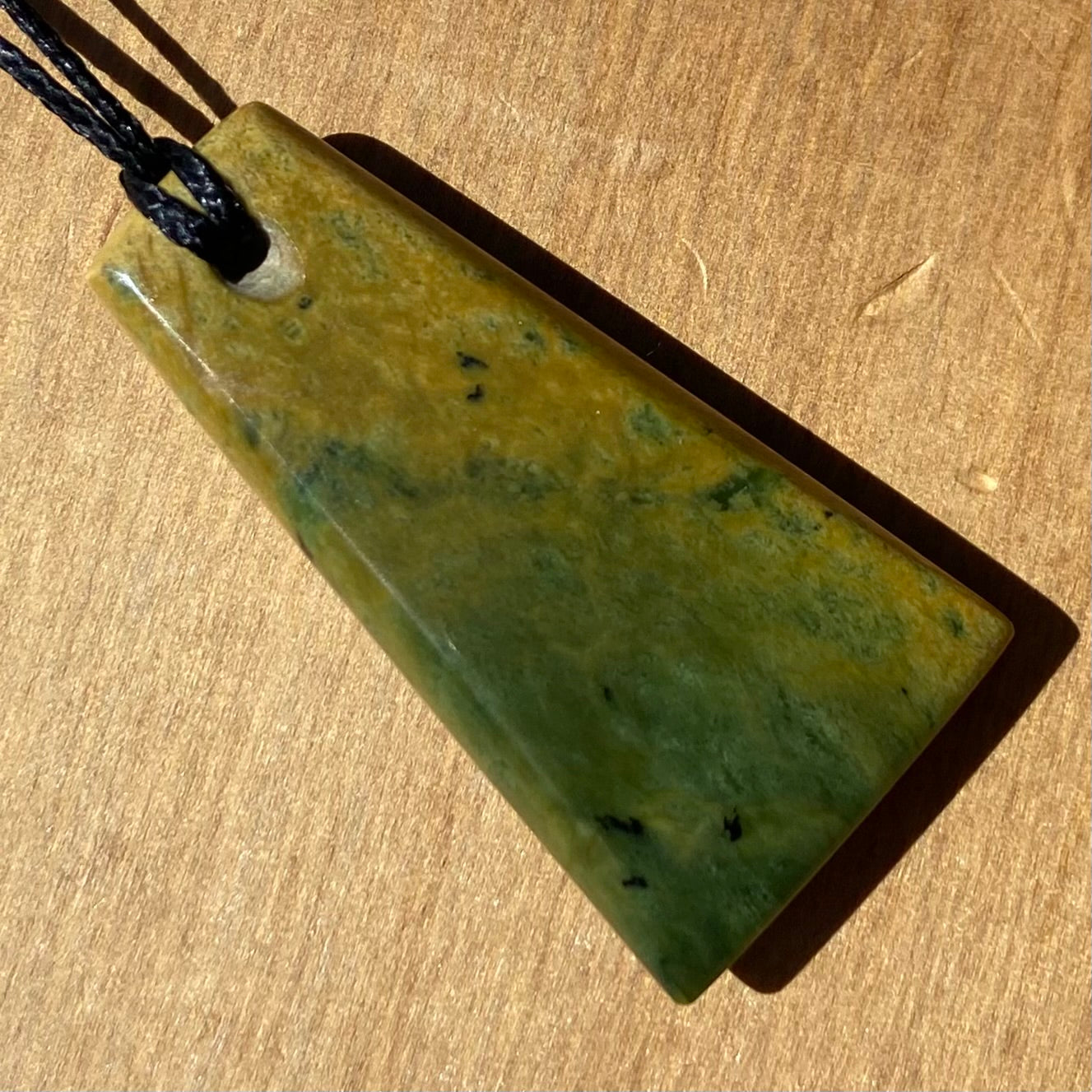Pounamu toki pendant hand-carved from New Zealand Marsden Flower Jade pounamu (greenstone). Back.