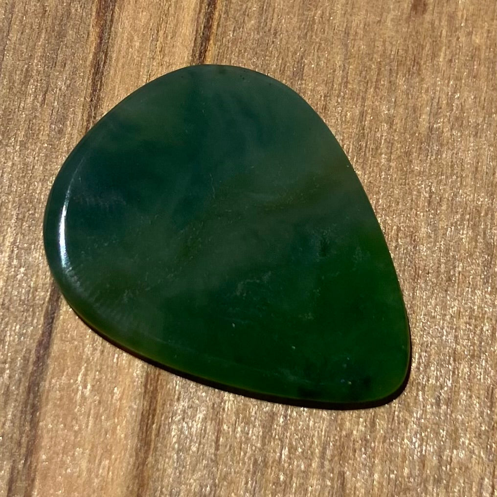 Guitar pick hand-carved from New Zealand Kahurangi Greenstone pounamu (greenstone). Front.