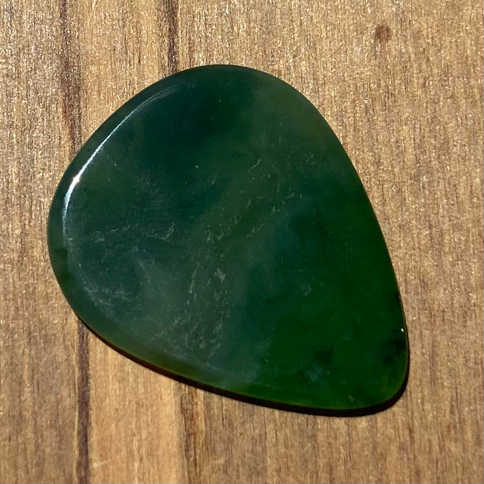 Guitar pick hand-carved from New Zealand Kahurangi Greenstone pounamu (greenstone). Back.