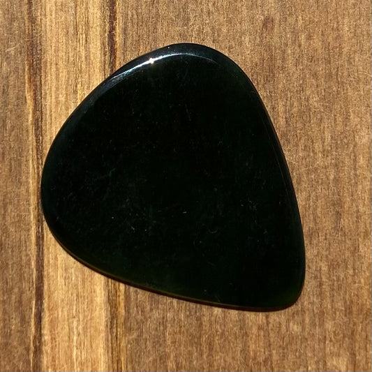 Guitar pick hand-carved from New Zealand Kawakawa Greenstone pounamu (greenstone). Front.