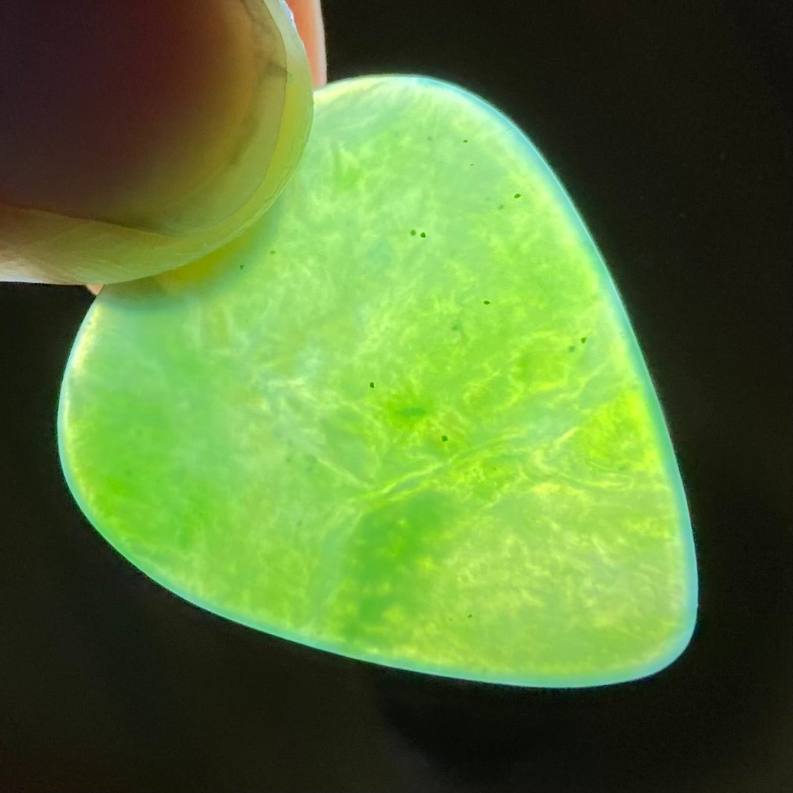 Guitar pick hand-carved from New Zealand Kahurangi Greenstone pounamu (greenstone). Translucency.