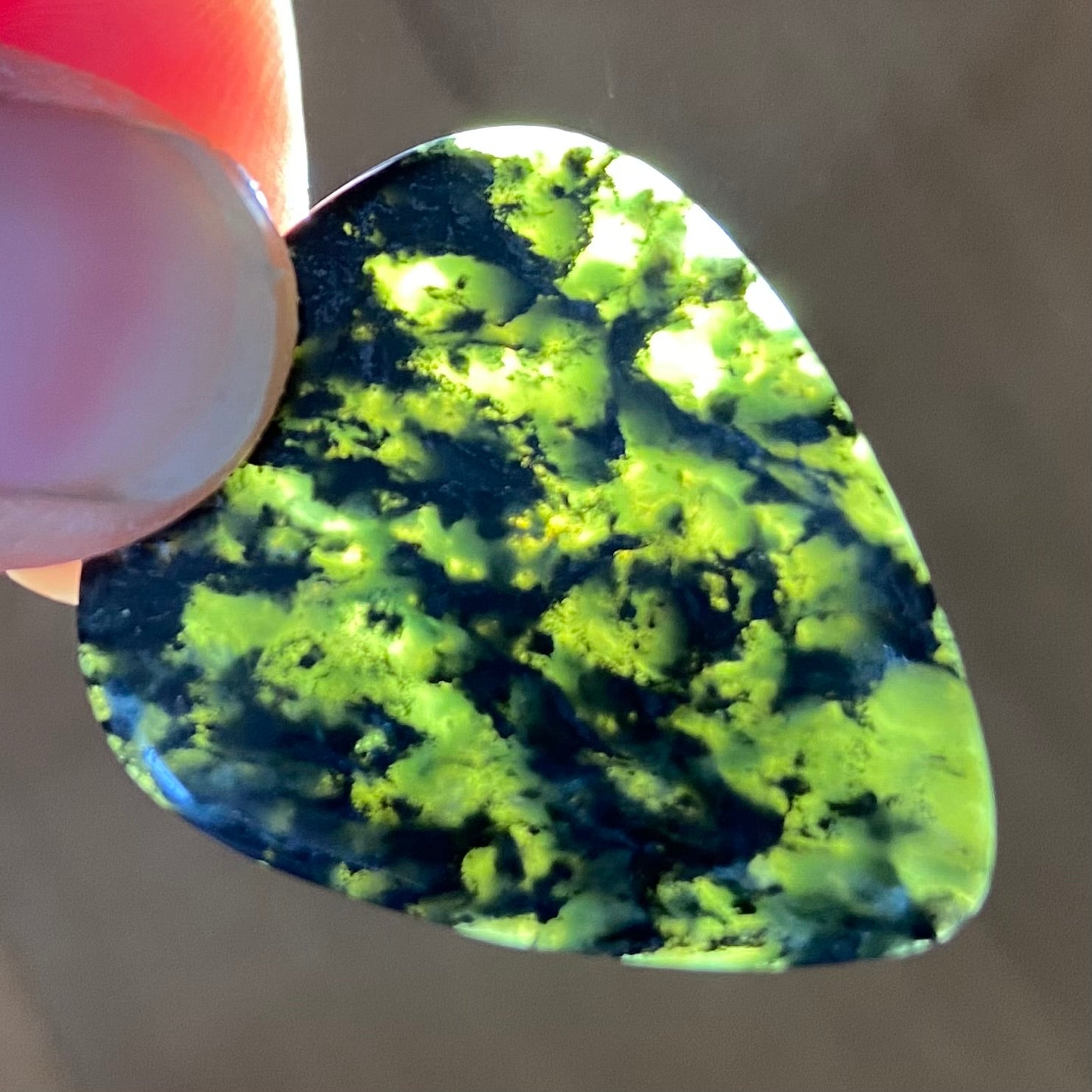 Guitar pick hand-carved from New Zealand Douglas Creek pounamu (greenstone). Translucency.