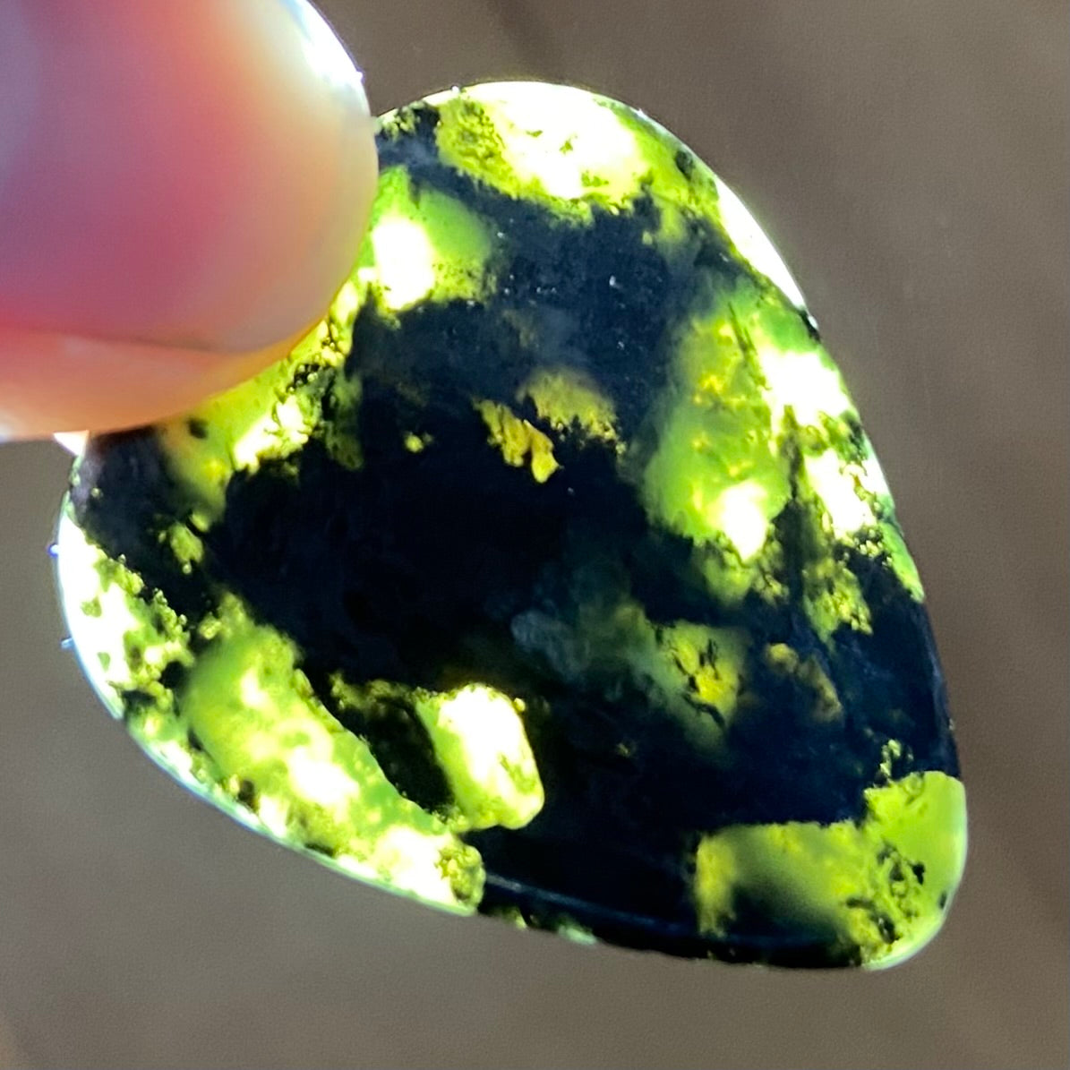 Guitar pick hand-carved from New Zealand Douglas Creek pounamu (greenstone). Translucency.