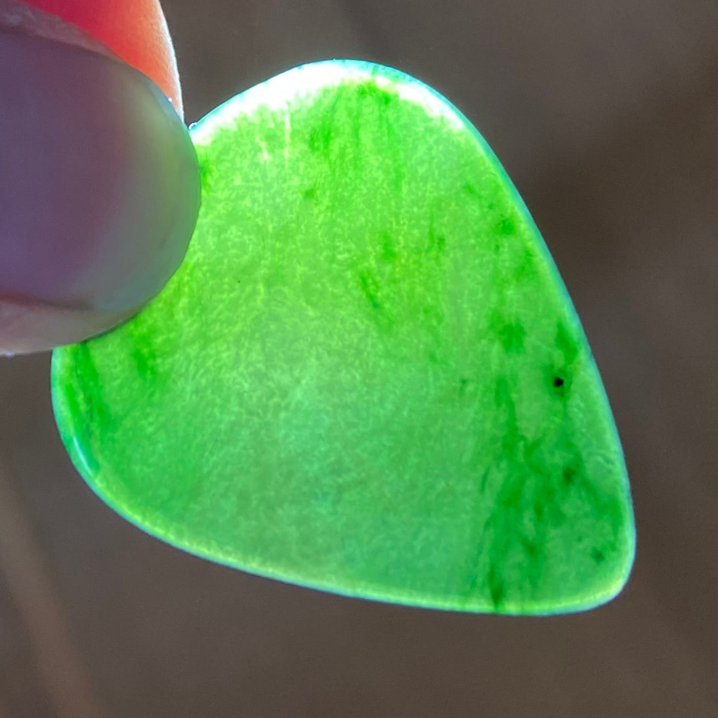 Guitar pick hand-carved from New Zealand Kawakawa Greenstone pounamu (greenstone). Translucency.