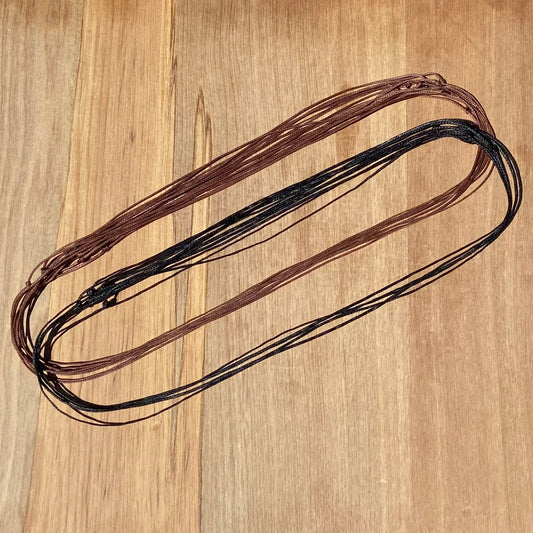 Black and brown adjustable pendant cords made from waxed polyester.