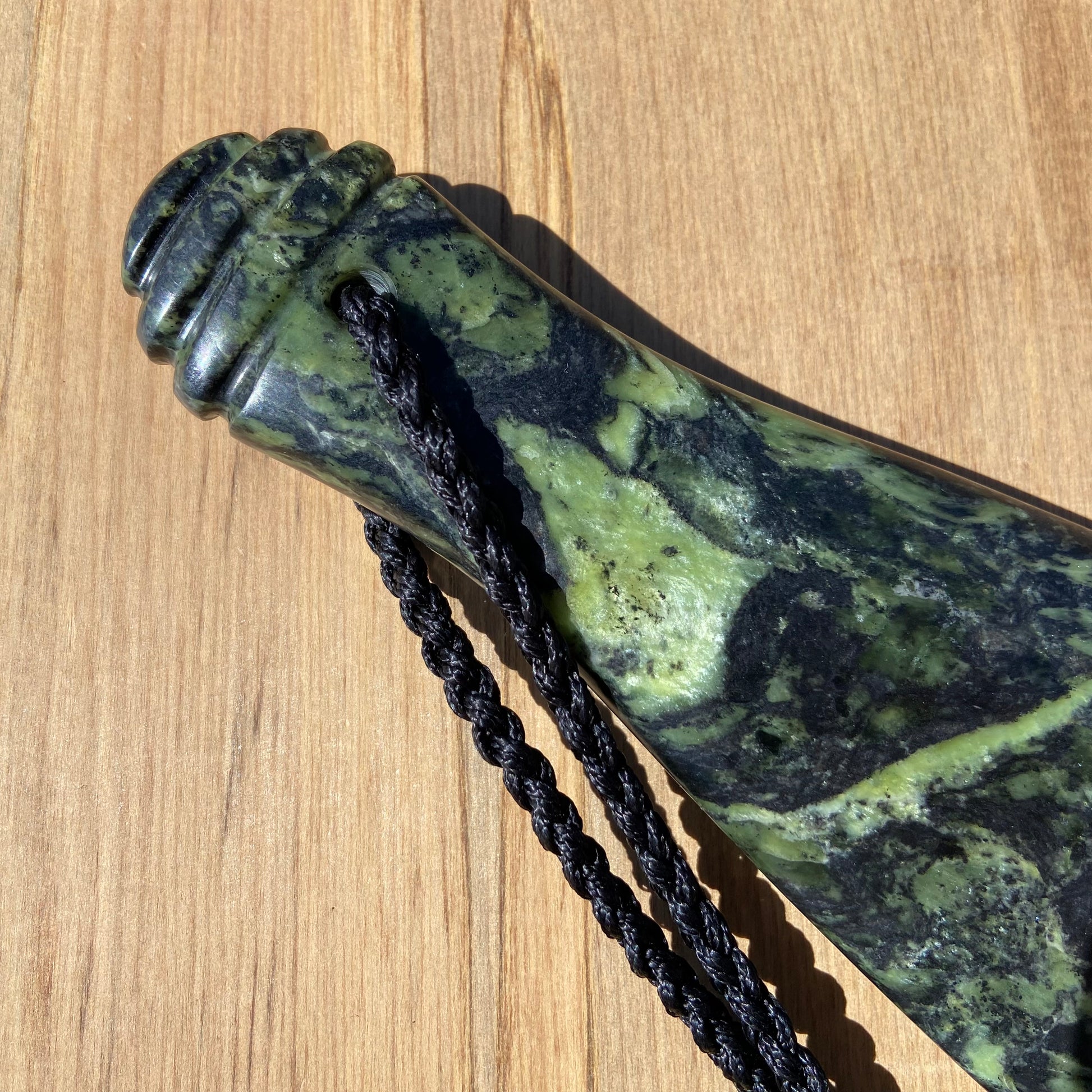 Pounamu mere hand-carved from Douglas Creek greenstone (pounamu). Close-up of handle.