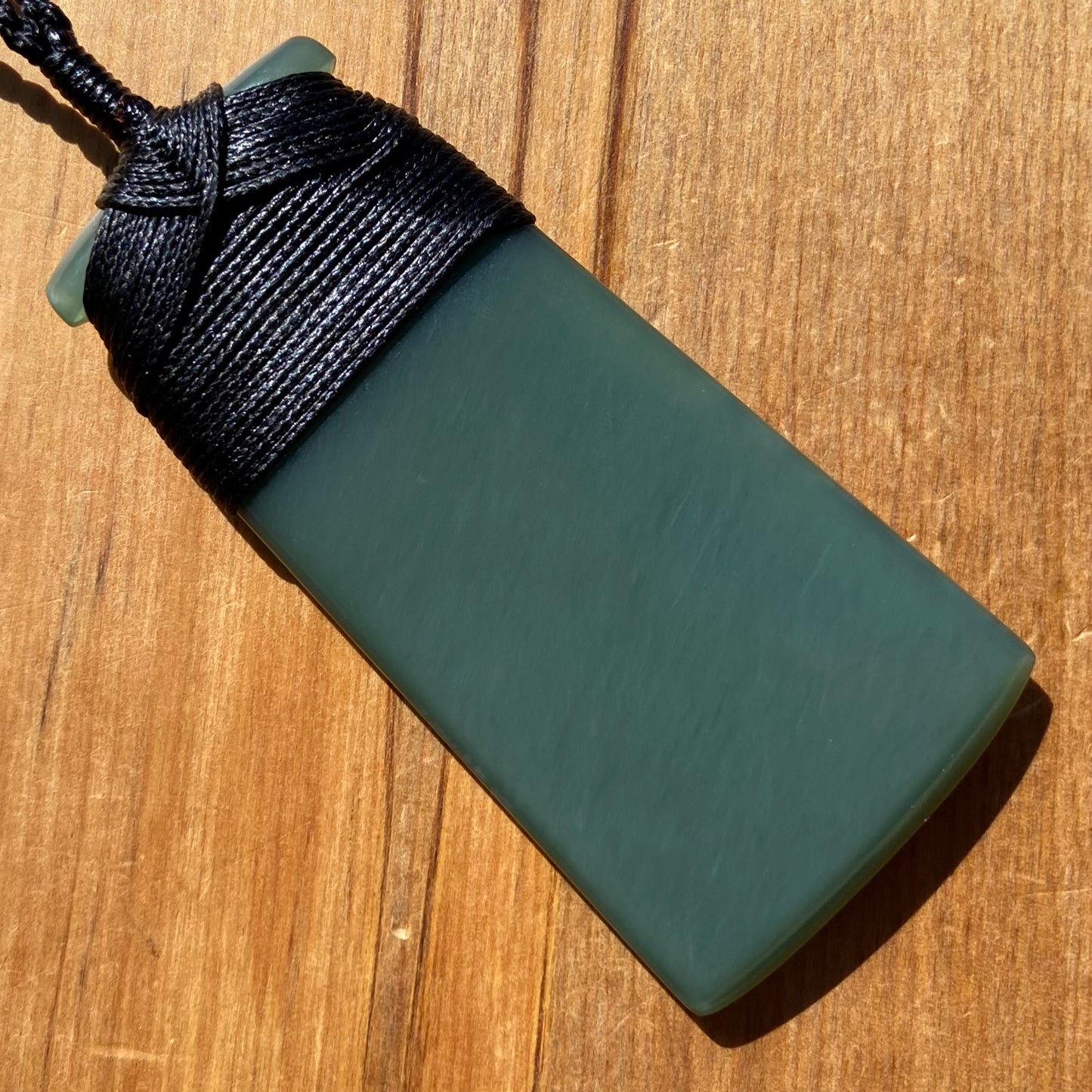 Bound toki pendant hand-carved from New Zealand inanga pounamu (greenstone). Back.