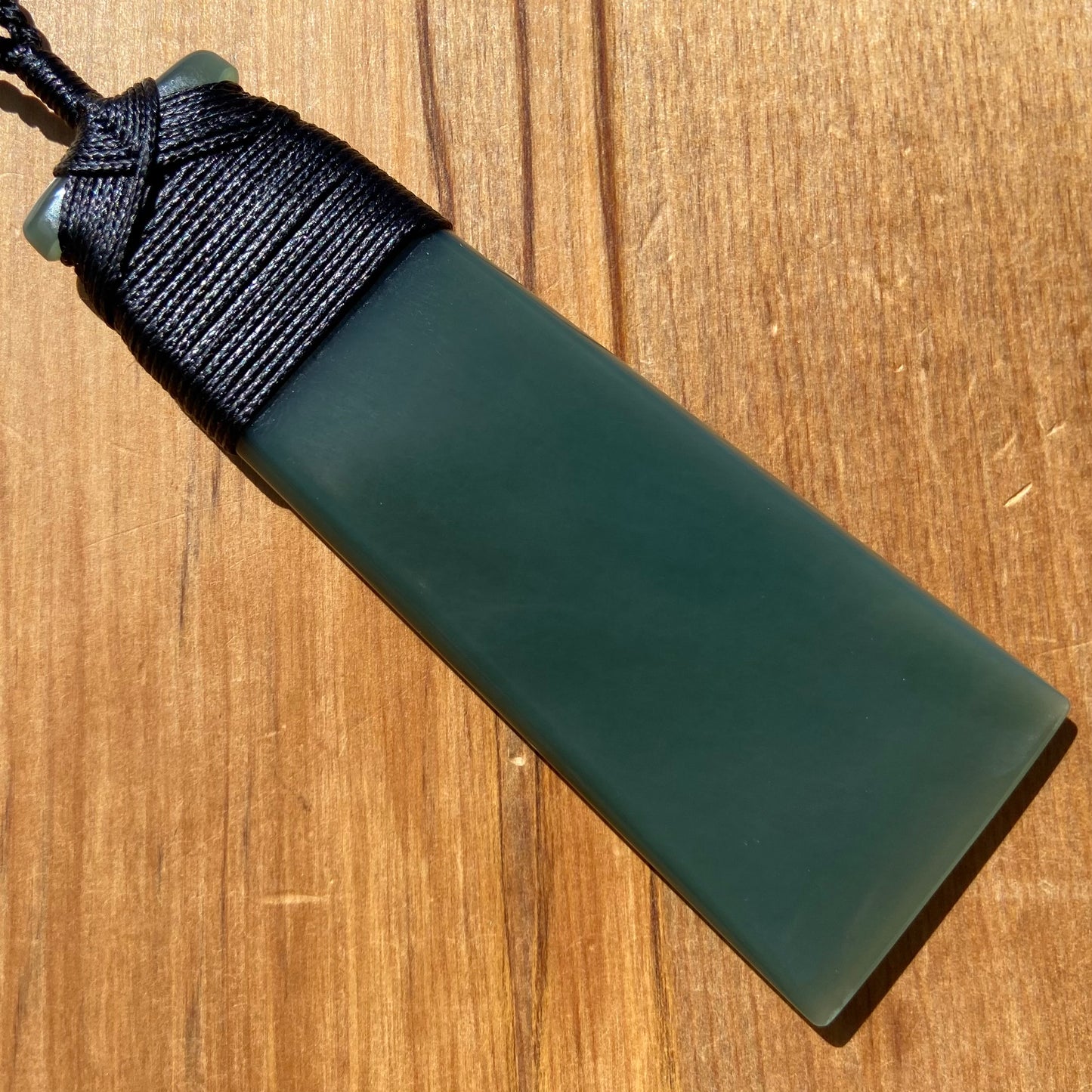 Bound toki pendant hand-carved from New Zealand inanga pounamu (greenstone). Back.