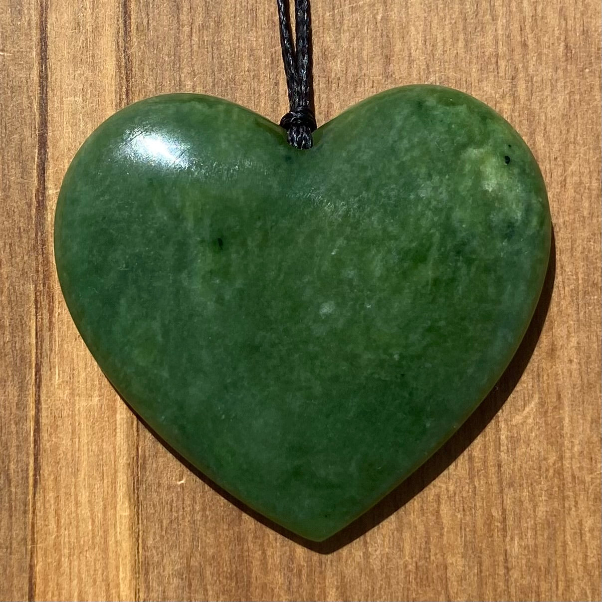 Heart shape pendant carved from New Zealand Marsden Flower Jade (greenstone). Front.