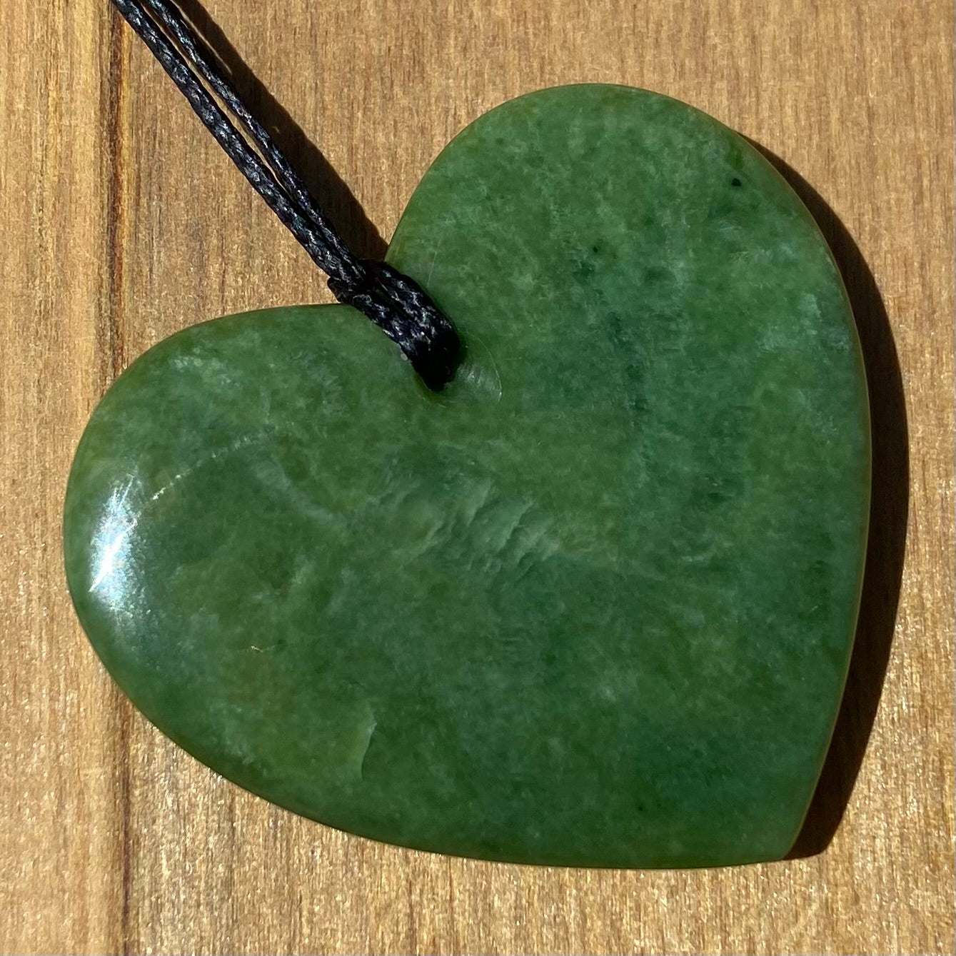 Heart shape pendant carved from New Zealand Marsden Flower Jade (greenstone). Back.