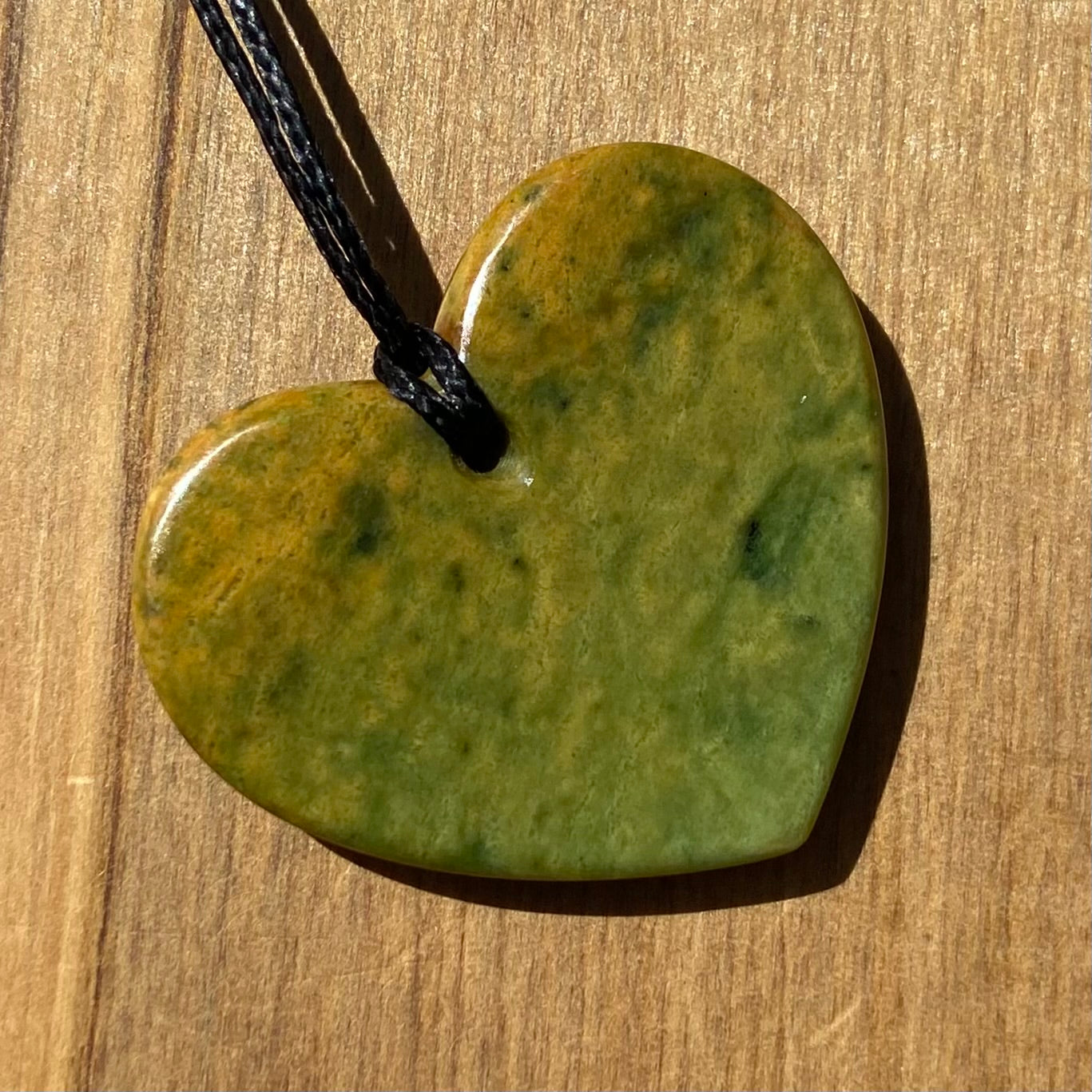 Heart shape pendant carved from New Zealand Marsden Flower Jade (greenstone). Back.