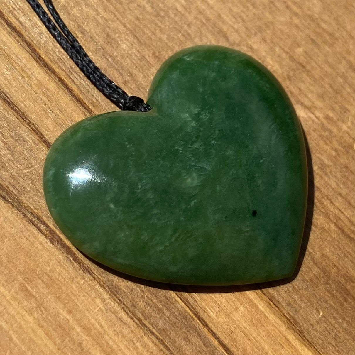 Heart shape pendant carved from New Zealand Marsden Flower Jade (greenstone). Front.