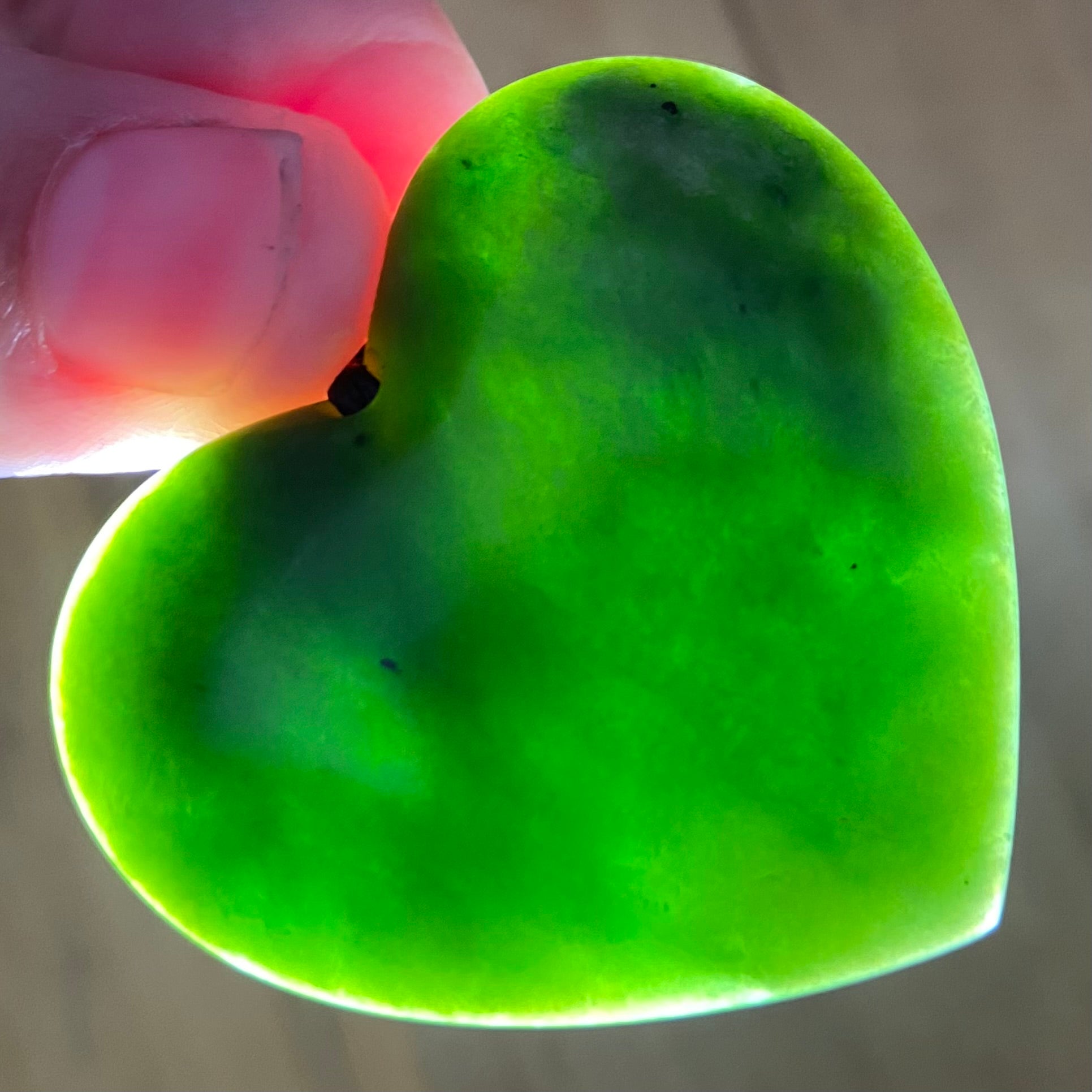 Heart shape pendant carved from New Zealand Marsden Flower Jade (greenstone). Translucency.