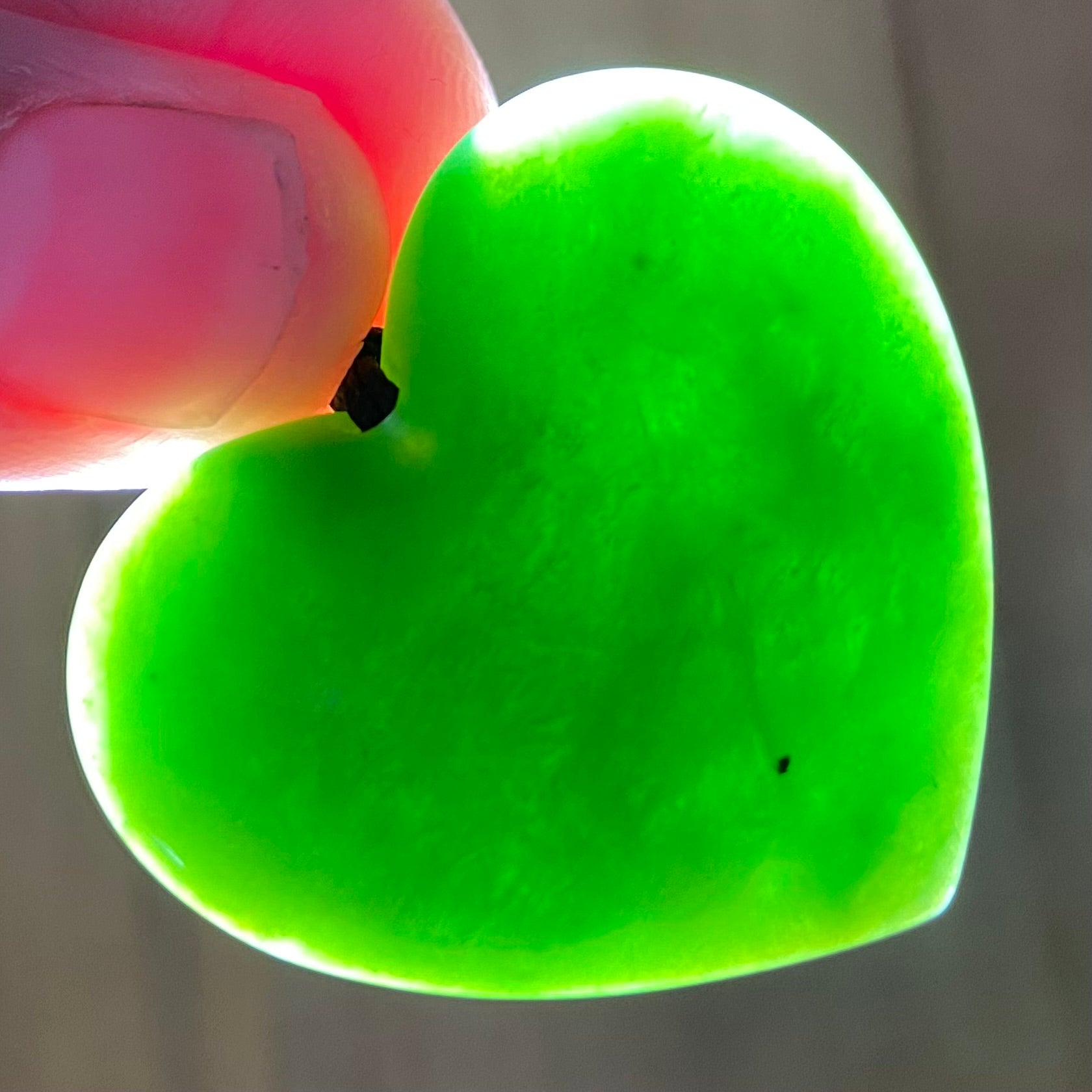 Heart shape pendant carved from New Zealand Marsden Flower Jade (greenstone). Translucency.