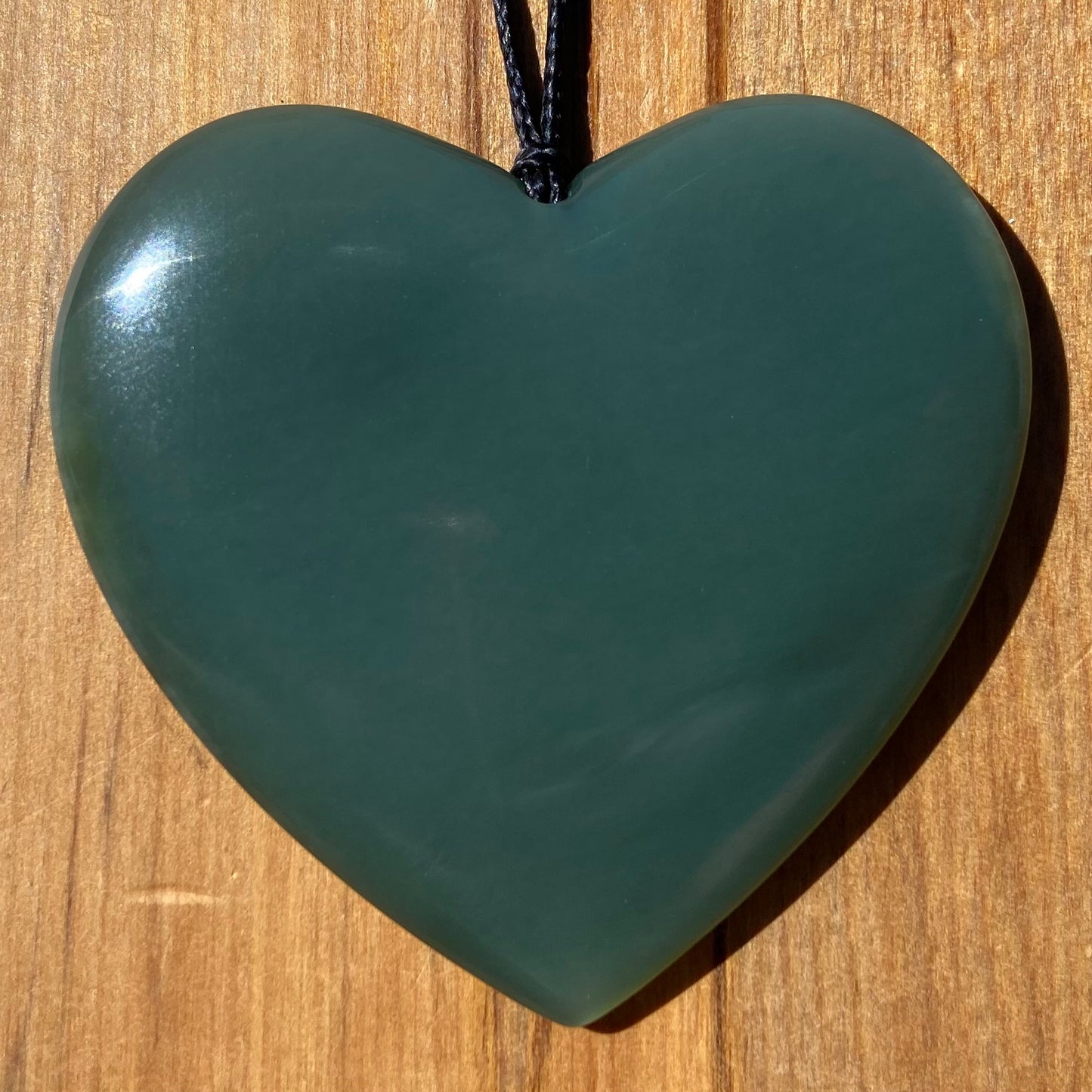 Large heart shaped pendant hand-carved from New Zealand inanga pounamu (greenstone). Front.