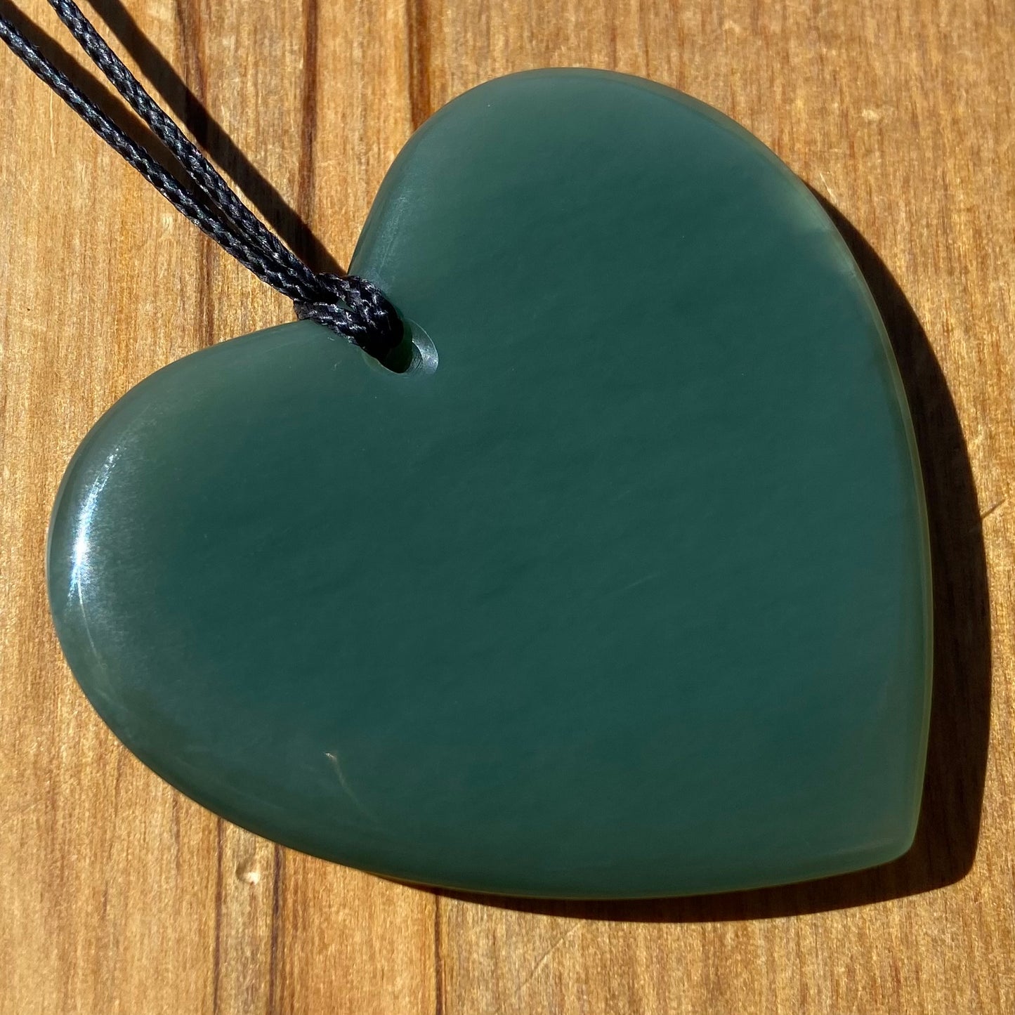 Large heart shaped pendant hand-carved from New Zealand inanga pounamu (greenstone). Back.