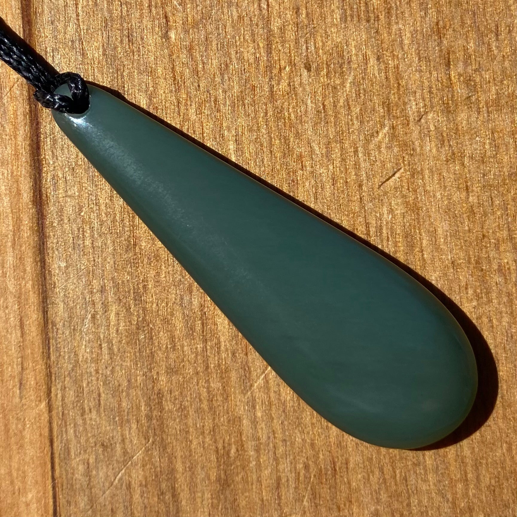 Roimata teardrop pendant carved from New Zealand inanga pounamu (greenstone). Front.