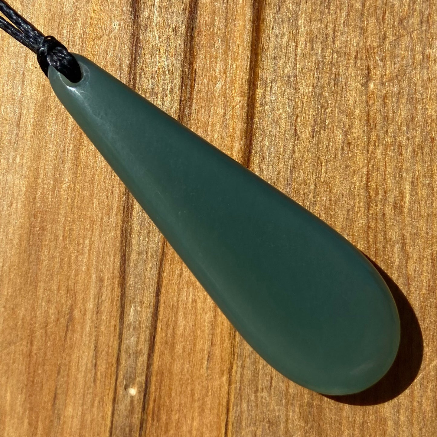 Roimata teardrop pendant carved from New Zealand inanga pounamu (greenstone). Back.