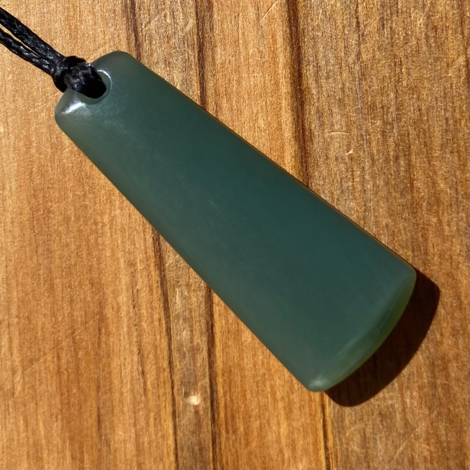Toki pendant hand-carved from New Zealand inanga pounamu (greenstone). Back.