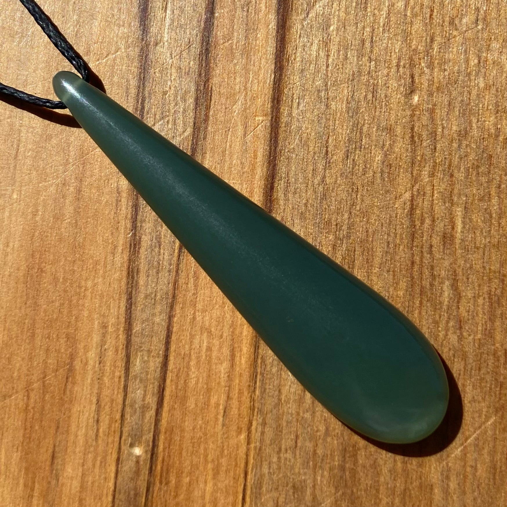 Roimata teardrop pendant carved from New Zealand inanga pounamu (greenstone). Front.