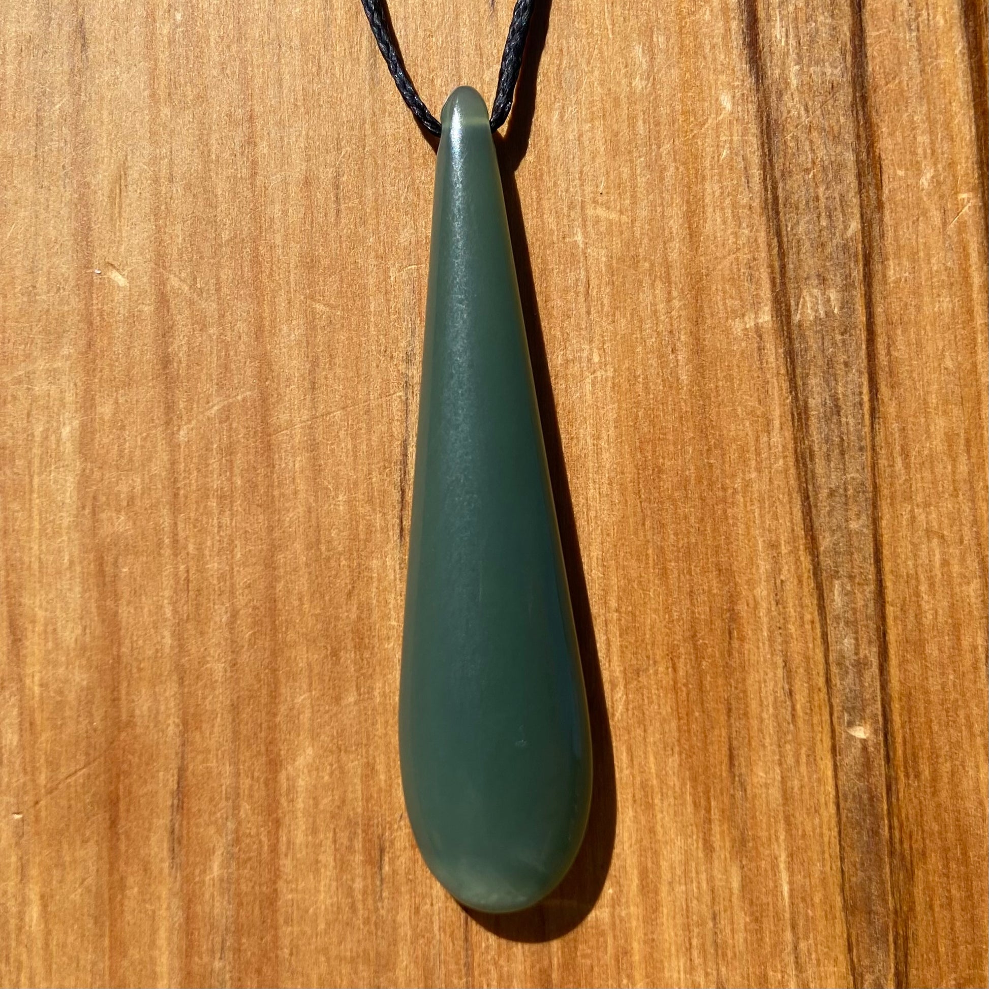 Roimata teardrop pendant carved from New Zealand inanga pounamu (greenstone). Front.