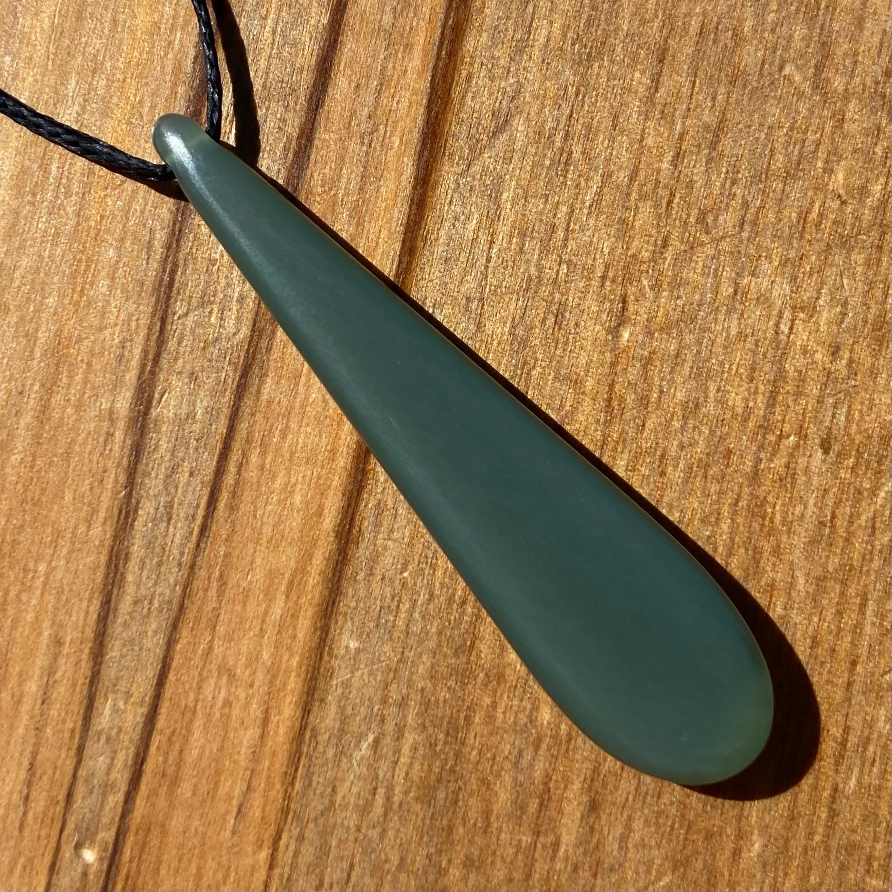 Roimata teardrop pendant carved from New Zealand inanga pounamu (greenstone). Back.