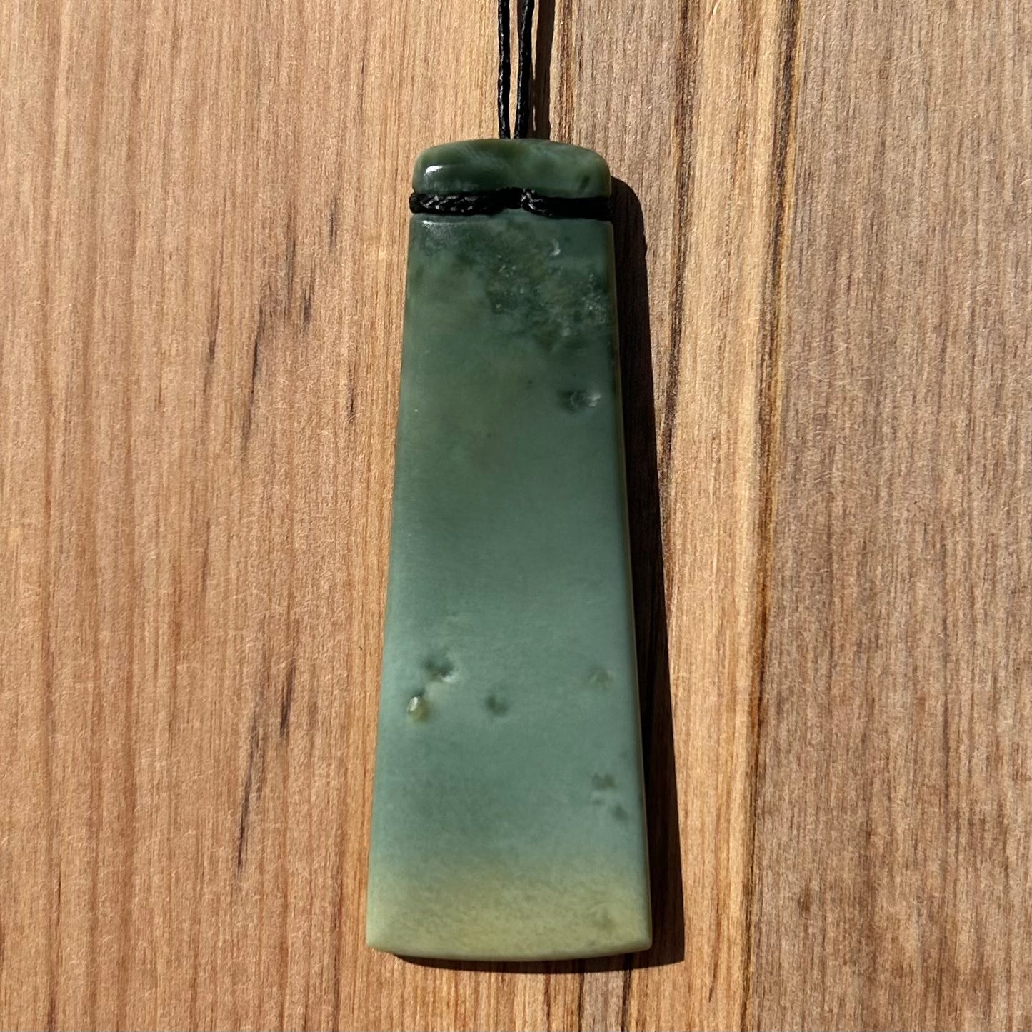 Toki pendant hand-carved from New Zealand inanga pounamu (greenstone). Back.