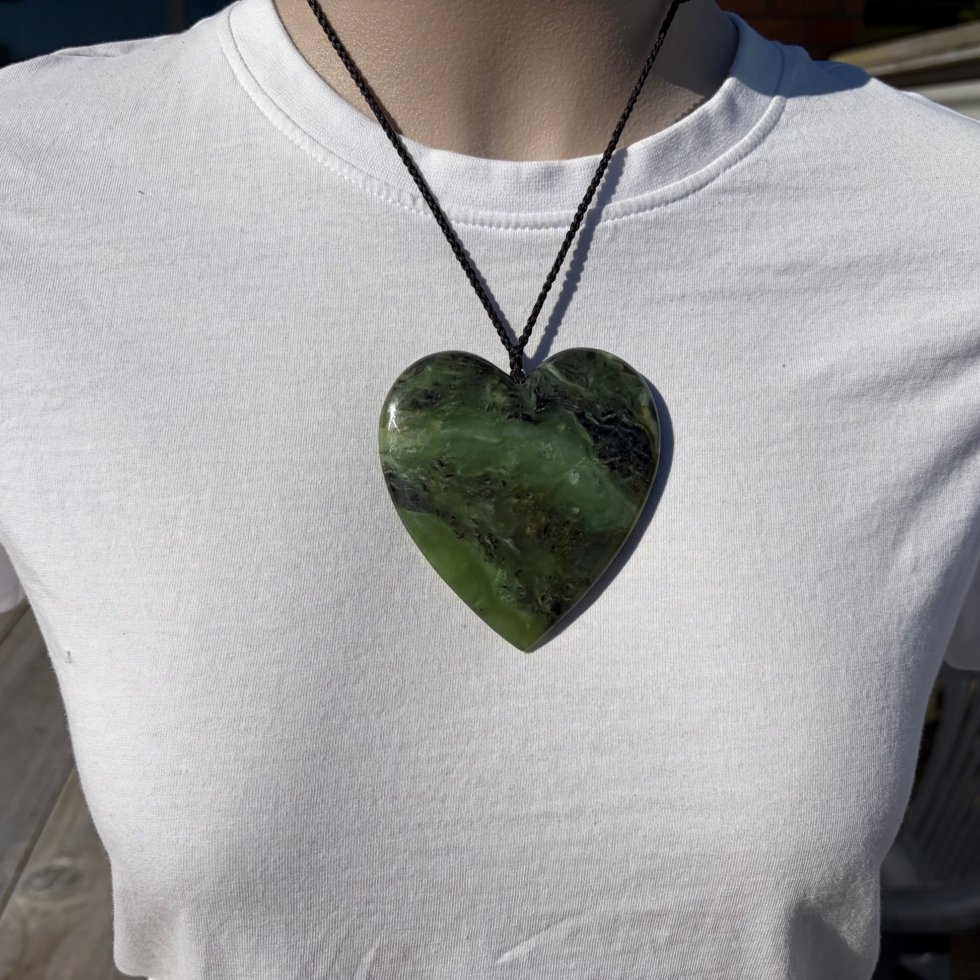 Heart pendant hand-carved from New Zealand kawawkawa pounamu (greenstone). Front.