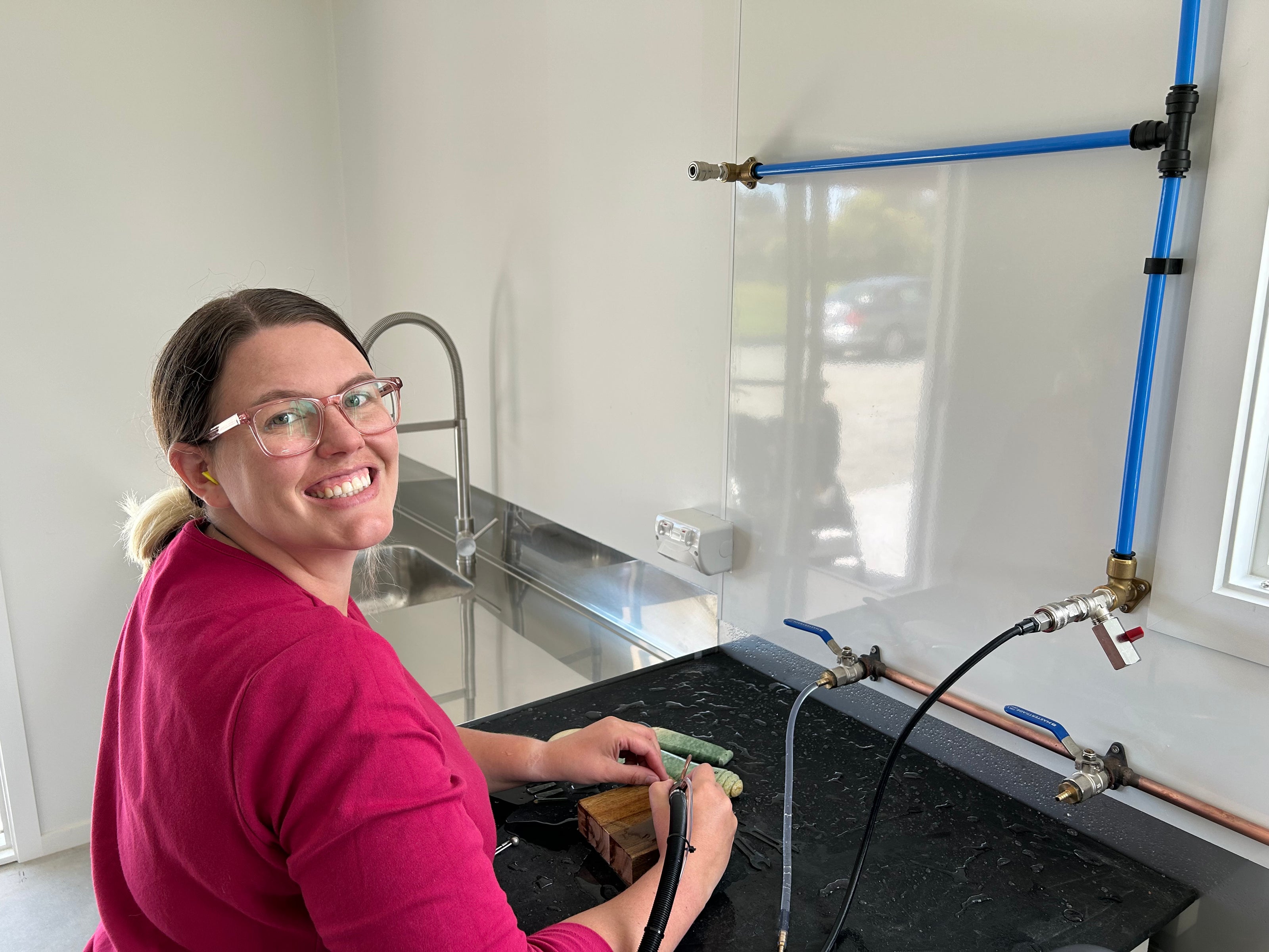 Brittany Lissington standing at her pounamu carving bench