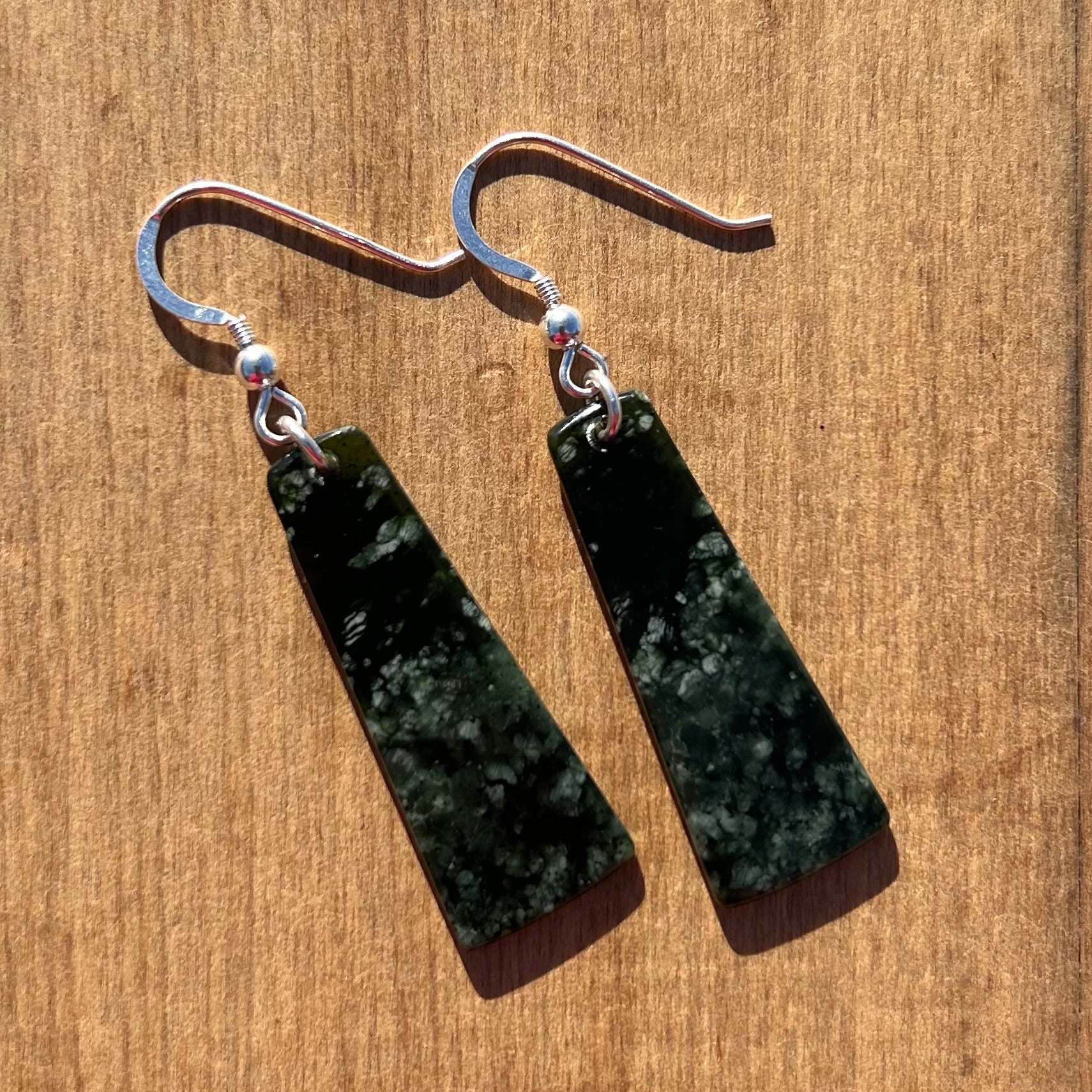 Pair of roimata (teardrop) earrings hand-carved from New Zealand pounamu (greenstone), with sterling silver fittings. Back.