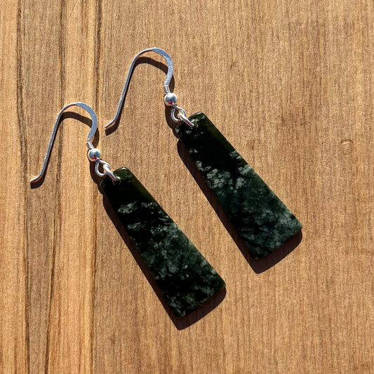 Pair of roimata (teardrop) earrings hand-carved from New Zealand pounamu (greenstone), with sterling silver fittings. Front.