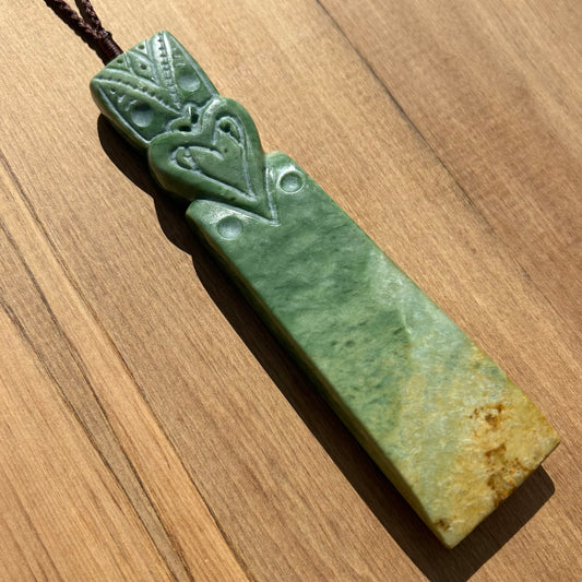 Tekoteko toki pendant hand-carved from New Zealand Marsden Flower Jade/ pounamu (greenstone). Front.