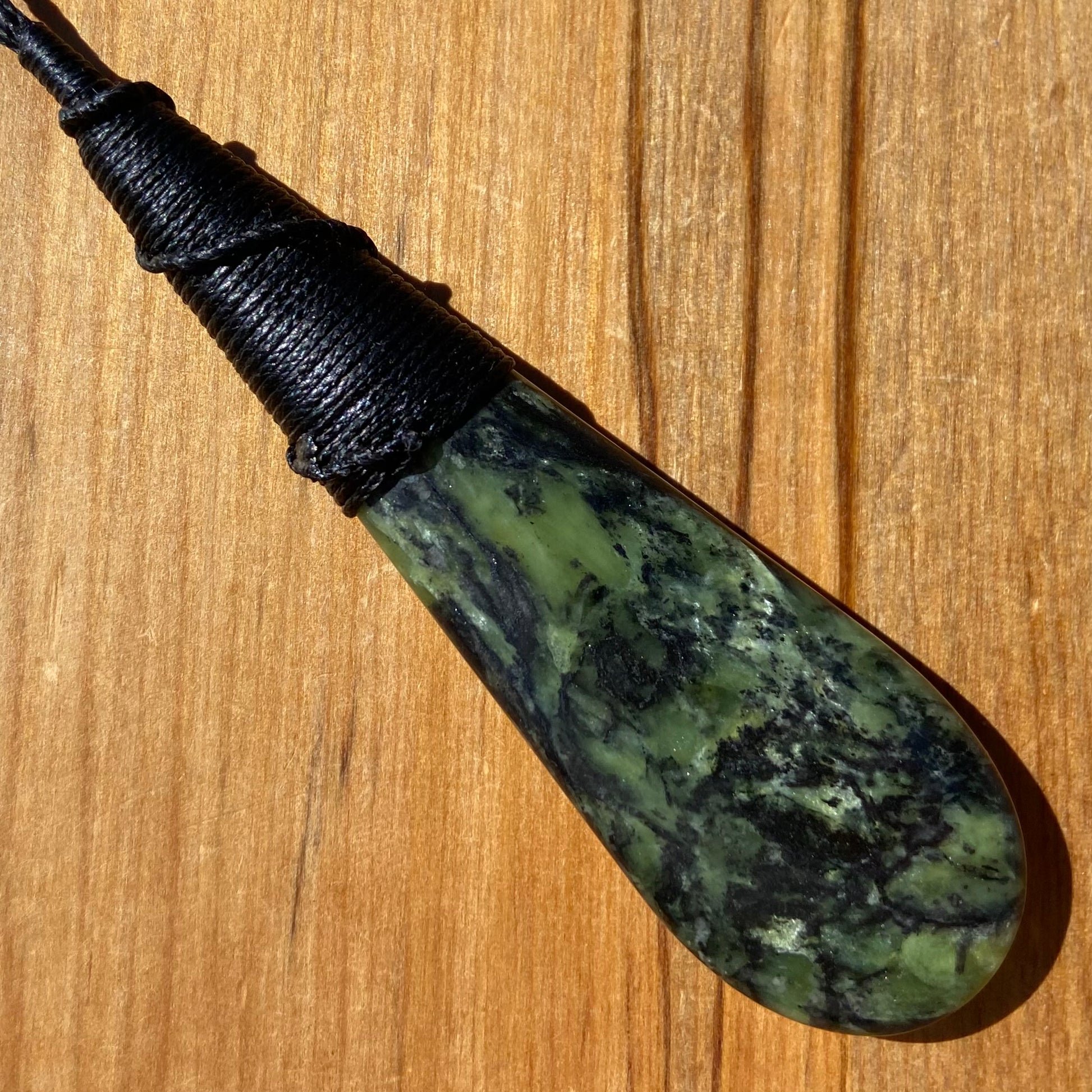 Bound roimata (teardrop) pendant hand-carved from New Zealand Douglas Creek pounamu (greenstone). Back.