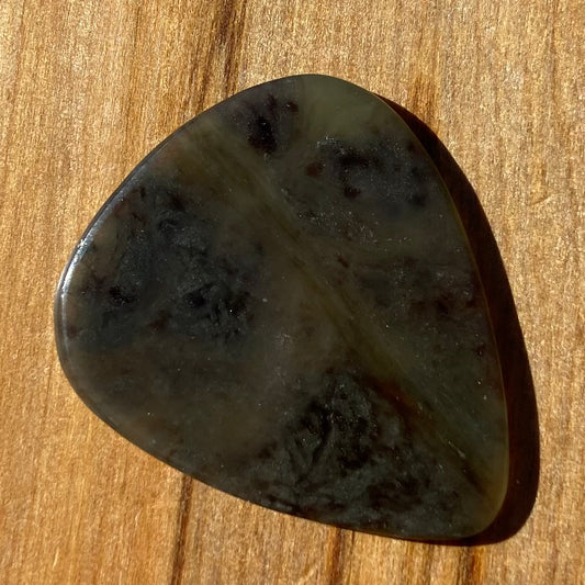 Guitar pick hand-carved from New Zealand Kawakawa Greenstone pounamu (greenstone). Front.