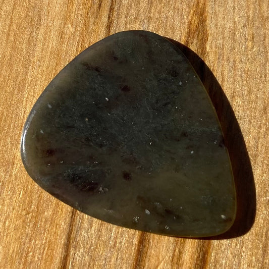 Guitar pick hand-carved from New Zealand Kawakawa Greenstone pounamu (greenstone). Front.