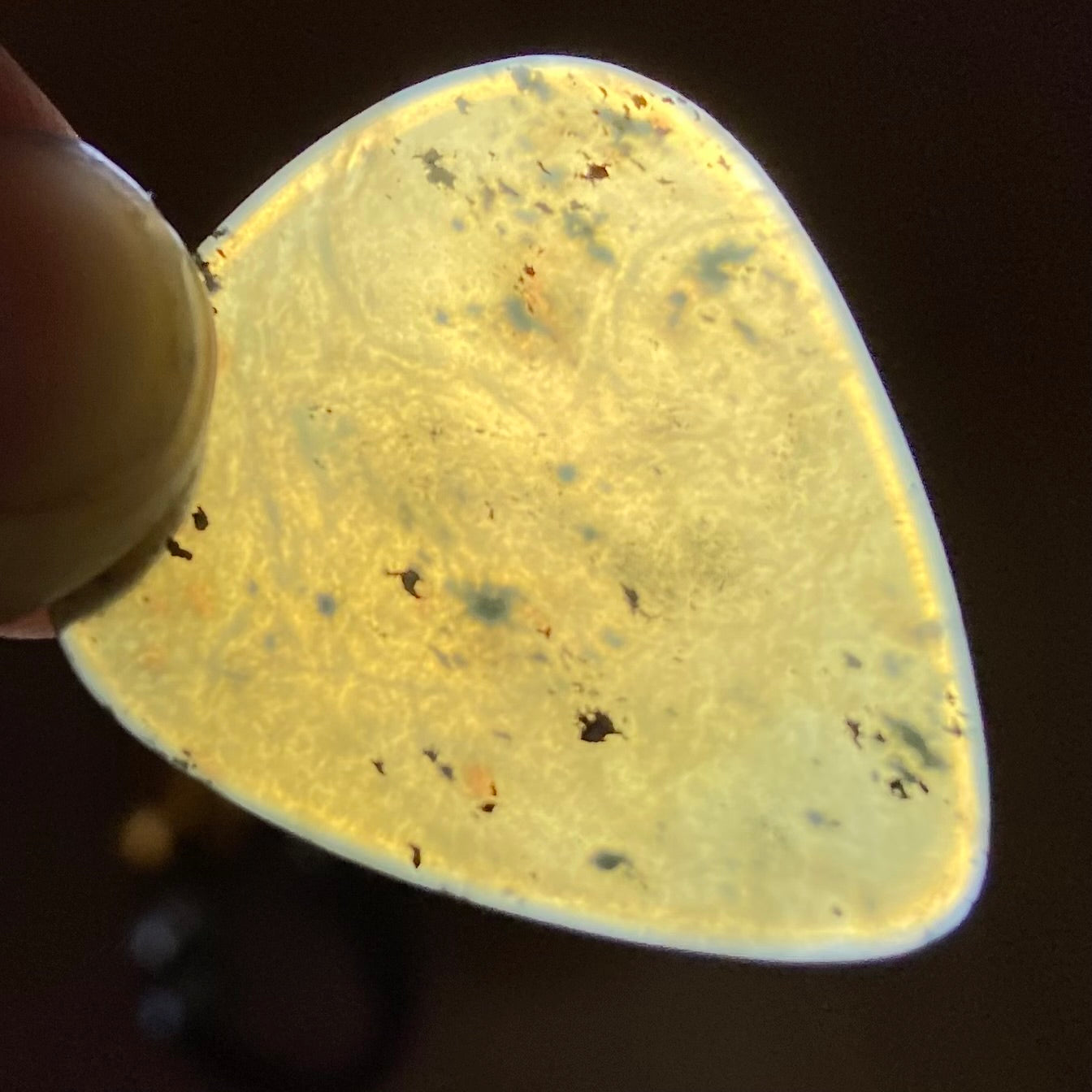 Guitar pick hand-carved from New Zealand Kawakawa Greenstone pounamu (greenstone). Translucency.