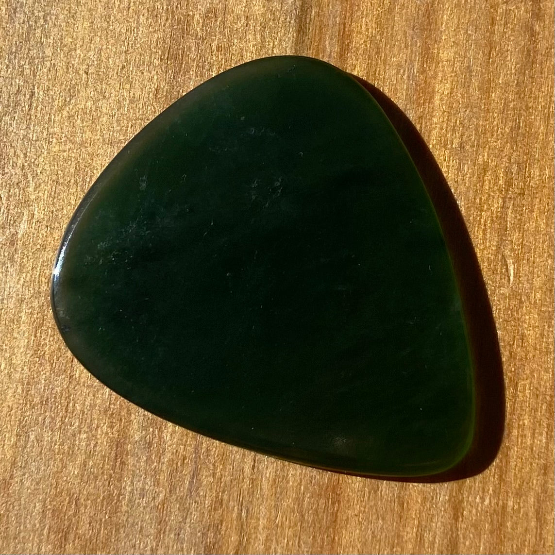 Guitar pick hand-carved from New Zealand Kahurangi Greenstone pounamu (greenstone). Front.